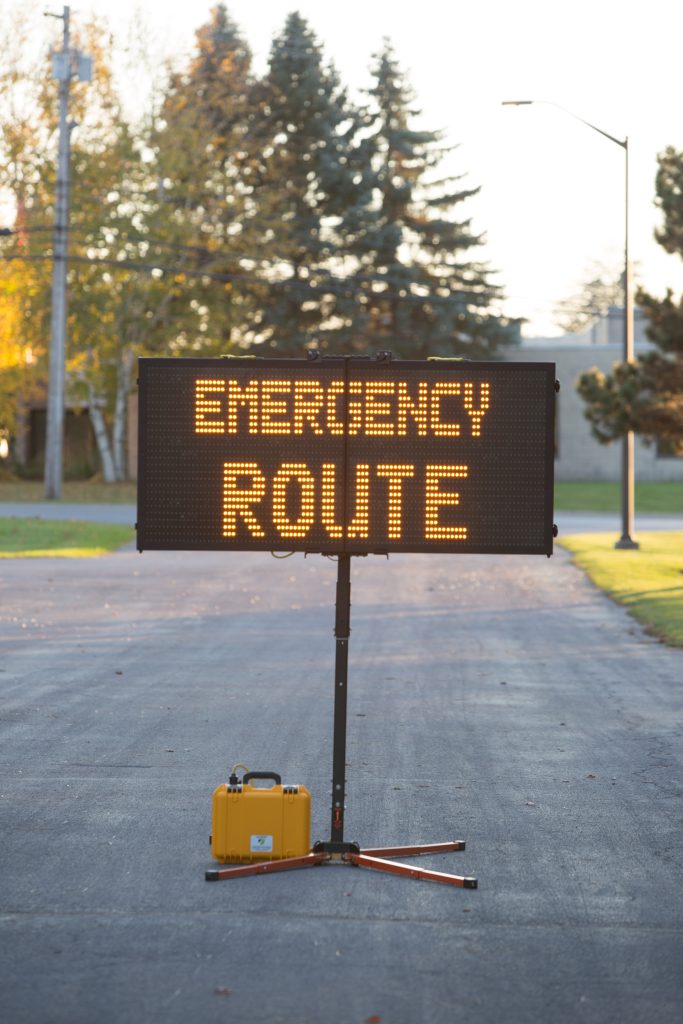 Visual display board stating, "Emergency Route" set up outside.