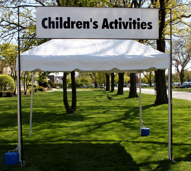 Children's Activities H-Pole sign set up outside in front of white tent.