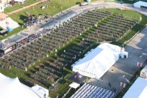 Bird's eye view of hundreds of bike racks set up outside beside a large white tent.