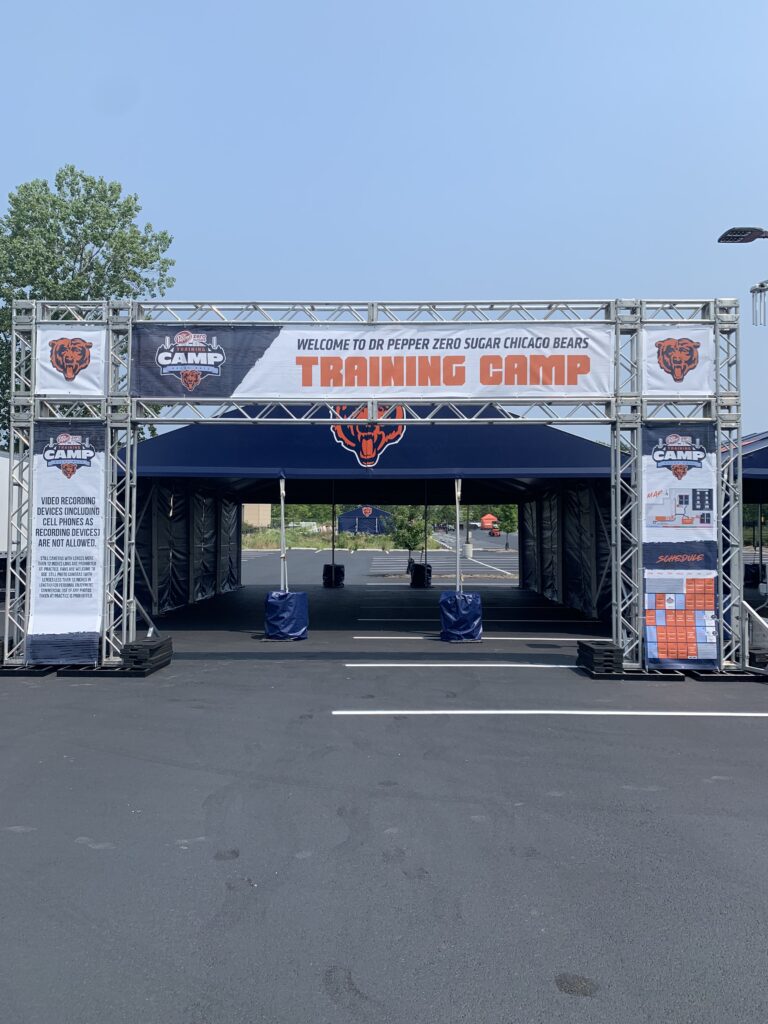 Chicago Bears training camp tent set up outside with truss structure for entrance.