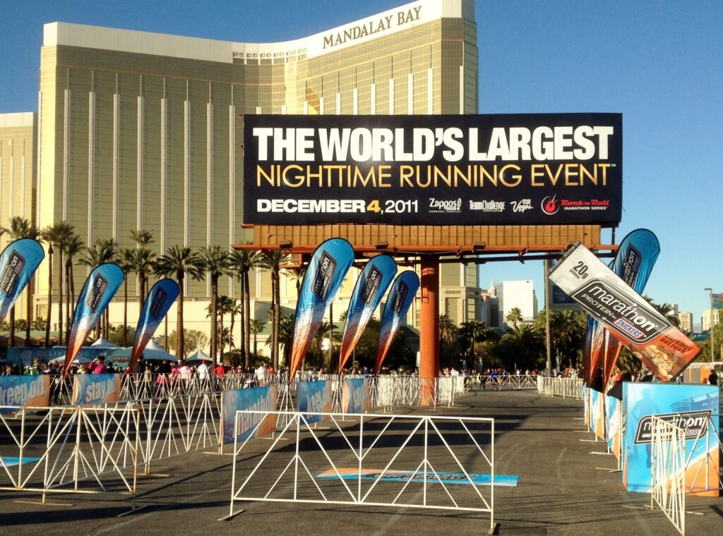 Outside of the Bandalay Bay building with French barricades out front and large billboard stating, "The World's Largest Nighttime Running Event."